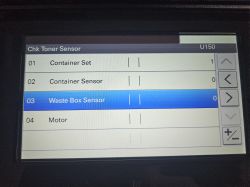 Ekran serwisowy drukarki z menu „Chk Toner Sensor” i pozycją „Waste Box Sensor” zaznaczoną.