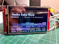 TFT display showing an internet radio UI “Radio Eska Rock” with audio bars on an electronics workbench