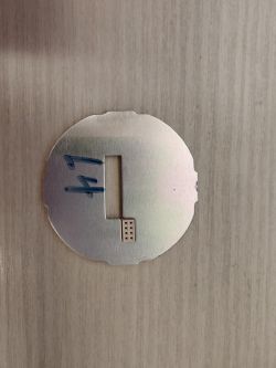 Metal plate of circular shape with a rectangular cutout and holes on a printed circuit board.