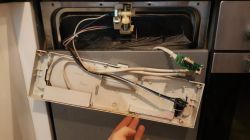 Rozłożona przednia część zmywarki z widocznymi przewodami i elementami elektronicznymi