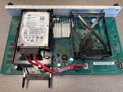 Otwarta obudowa urządzenia elektronicznego z widocznym dyskiem twardym Seagate 320GB SATA 2,5 i płytą główną.