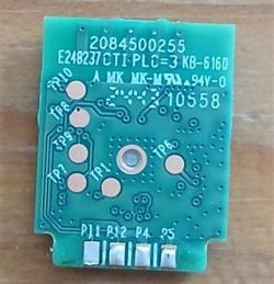 Small green PCB with printed numbers, circuit traces, and four silver contacts along the bottom edge