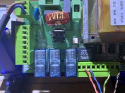 Zbliżenie na płytkę centralki sterującej z układem elektronicznym i przekaźnikami.