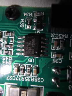 Close-up of an integrated circuit on a printed circuit board with markings.