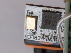 Close-up of an electronic circuit with visible chip elements and a gold component.