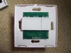 Top view of an open Axus 3-gang touch light switch, showing its PCB and three large touch buttons.