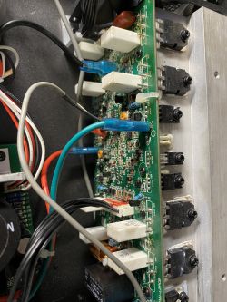 Zbliżenie na moduł elektroniczny z różnymi komponentami i okablowaniem wewnątrz obudowy.