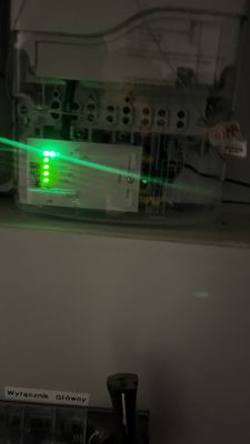 Zbliżenie na urządzenie z zielonymi diodami LED znajdujące się w rozdzielni elektrycznej.