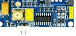 Zbliżenie na płytkę elektroniczną z różnymi komponentami i złączami.