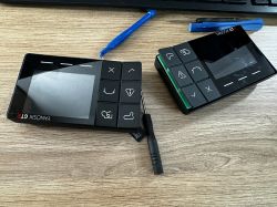 Two disassembled Yanosik GTR devices with exposed buttons and a screwdriver on a wooden desk.