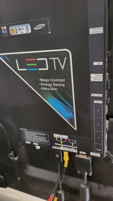 Zdjęcie tylnej części telewizora z widocznymi wejściami i oznaczeniami.