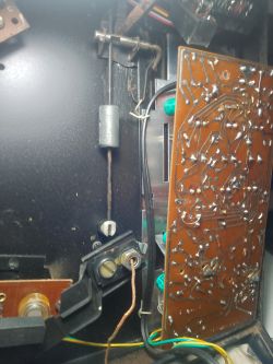 Zdjęcie wnętrza urządzenia elektronicznego z widoczną płytką drukowaną i okablowaniem.