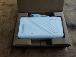 Powerbank Romoss SW20PF w białym kolorze, zapakowany w brązowe kartonowe pudełko, częściowo owinięty folią ochronną.
