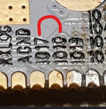 Close-up of PCB pin labels with a red U-shaped marker drawn on it