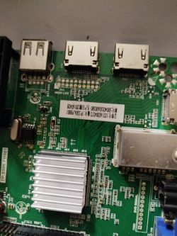 Zbliżenie na płytę główną urządzenia z widocznymi portami USB i fragmentem radiatora.