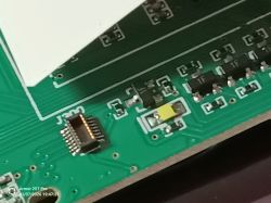 Close-up of a green PCB with J300 connector and surface-mounted electronic components