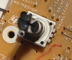 Enkoder obrotowy na PCB urządzenia audio Zbliżenie enkodera obrotowego na płytce drukowanej, z metalowym korpusem i czarną osią