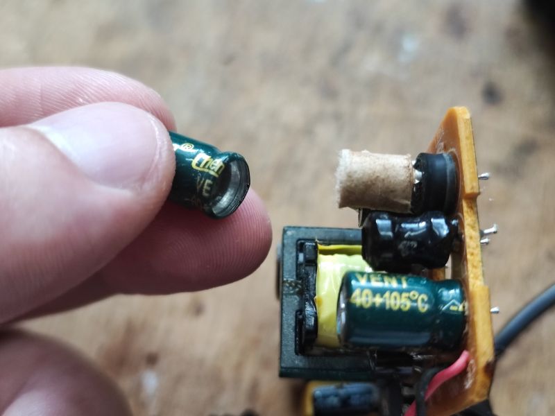 Zbliżenie na uszkodzony kondensator zasilacza.