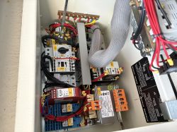 Wnętrze szafy sterowniczej frezarki z widoczną instalacją elektryczną i przekaźnikami