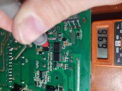 Close-up of an electronic circuit with a meter showing voltage of 6.96 V.