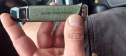 Close-up of a green electronic vaping device labeled VAPING REMAINDER, held in hand, with a damaged corner.