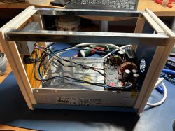 Open bench power supply case with converter board, wiring, and a label reading S-1200-60