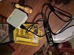USB to RS485 adapter connected to a TP-Link router and a tool kit on a wooden table.