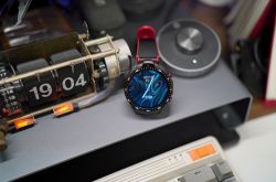 Mechanical clock and smartwatch on a desk.