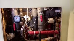 Inside CWU Boiler Housing View inside CWU boiler housing with installed pipes and valve controller.