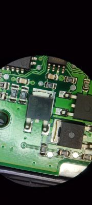 Fragment płytki PCB modułu ABS z widocznymi tranzystorami, rezystorami i ścieżkami.