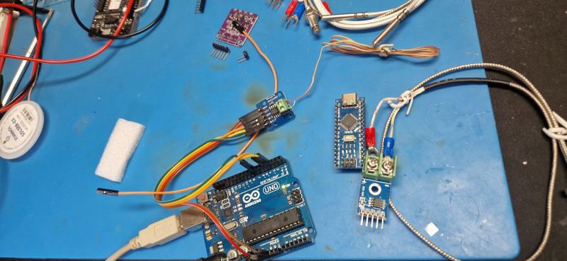 Arduino UNO połączone z modułem MAX31855K i termoparą na niebieskiej macie.