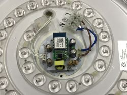 Circuit board with an electronic module mounted inside a lighting fixture.
