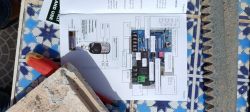 Instruction manual of an electronic module on a table with tools and accessories.