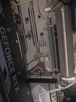 Widok wewnętrzny komputera z kartą graficzną GeForce RTX i płytą główną z modułami pamięci.