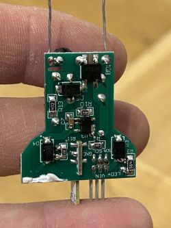 Printed circuit board with electronic components held in a hand.