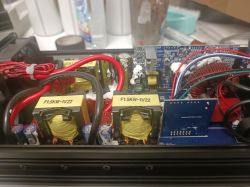 Wnętrze przetwornicy z widocznymi transformatorami i przewodami.