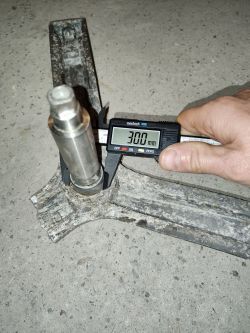 Zdjęcie metalowego krzyżaka bębna pralki, z miernikiem cyfrowym pokazującym średnicę 30 mm.