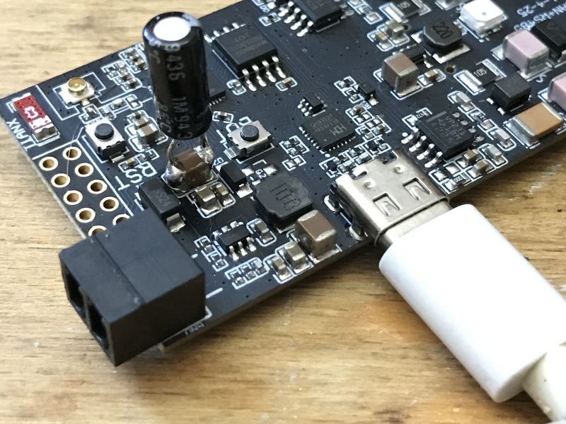 Close-up of LilyGO board with soldered capacitor and USB cable