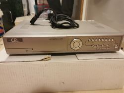 Rejestrator cyfrowy CP Cam 4CH MPEG 4 DVR z kablem zasilającym na białym kartonie.