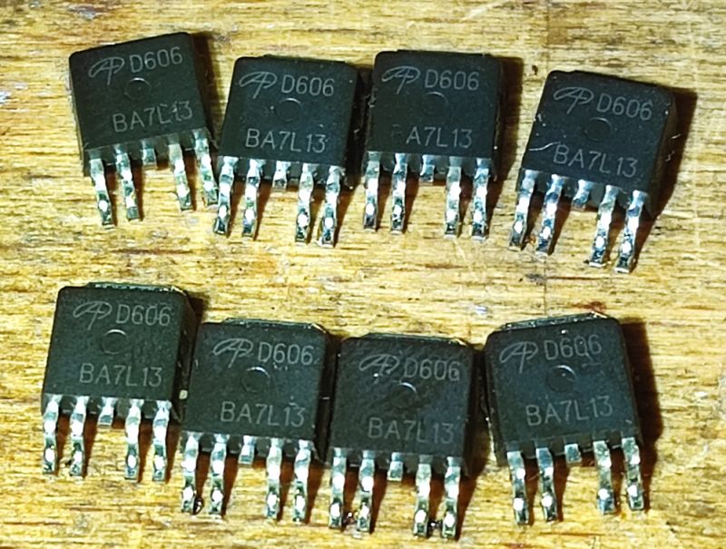 D606 Transistors on Wooden Background Seven D606 transistors with BA7L13 markings on a wooden background.