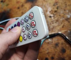 LED Controller Remote with Battery Cover LED controller remote held in hand with visible transparent battery cover.