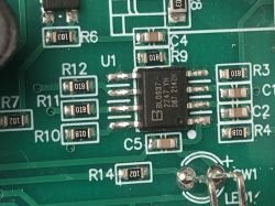 Close-up of a printed circuit board with an integrated circuit, resistors, and capacitors.