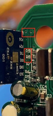 Close-Up of TX/RX Pins on Smart Tap Mini Circuit Board Close-up of a circuit board with highlighted TX/RX pins and components labeled R8/R9.