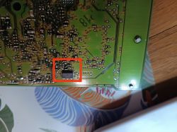 Fragment płytki drukowanej z zaznaczonym na czerwono miejscem po usuniętych elementach elektronicznych, prawdopodobnie kondensatorach.