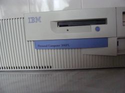 Zbliżenie na przedni panel komputera IBM Personal Computer 300PL z logo IBM i napędem.