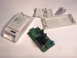 Disassembled WiFi Relay Housing with PCB Disassembled WiFi relay housing with visible PCB and accessories.