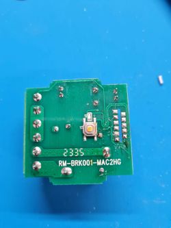Close-up of a circuit board labeled RM-BRK001-MAC2HG on a blue background.