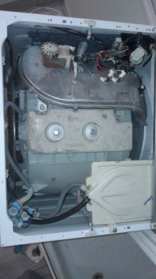 Widok wnętrza pralko-suszarki Beko model HTV8732XCW z widocznymi przewodami i elementami mechanicznymi.