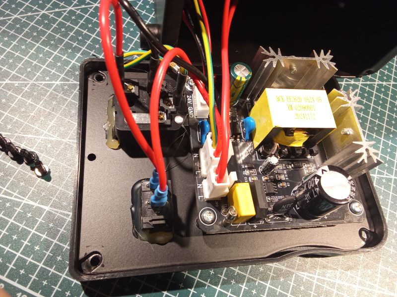 Wnętrze urządzenia elektronicznego z widocznym zasilaczem impulsowym