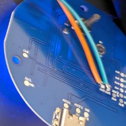 PCB with Wires and USB-C – Huggwic Tuya WiFi IR Remote Control Close-up of a blue PCB with orange and blue wires soldered and a visible USB-C port.